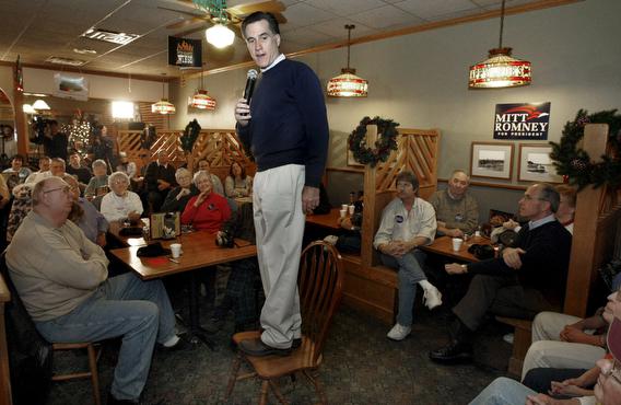 itt Romney (C) speaks to a group of supporters while standing on a chair at Happy Joe's in Clinton, Iowa, USA