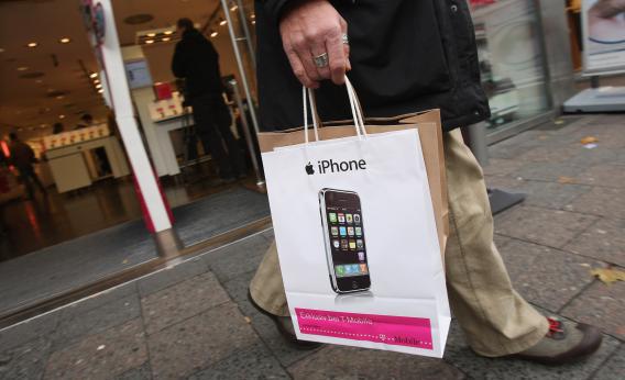 A customer leaves with a just-purchased Apple iPhone at a T-Mobile.