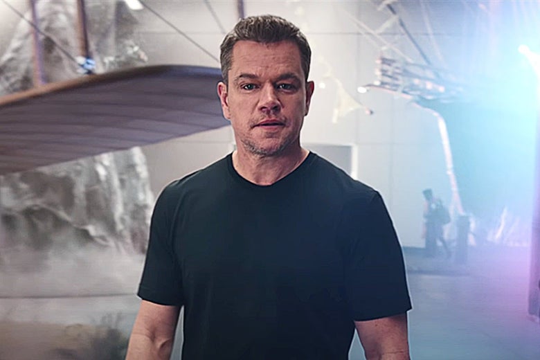 Matt Damon stands in front of an old airplane wing.