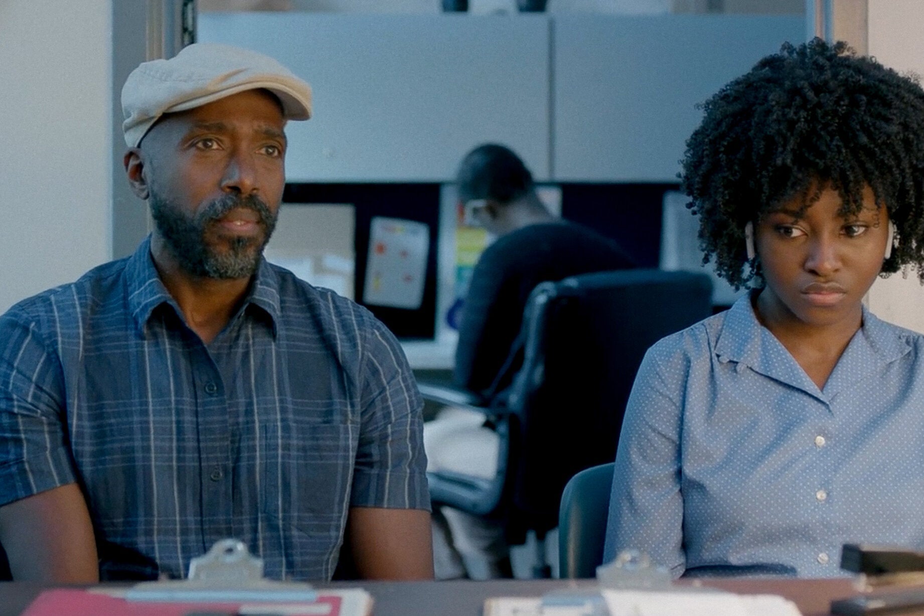 Ntare Mwine and Jayme Lawson sit behind a desk.