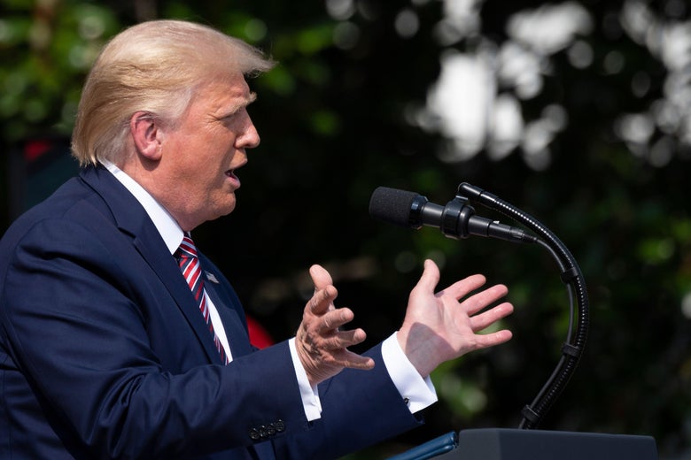 Trump gestures while speaking at a podium outside