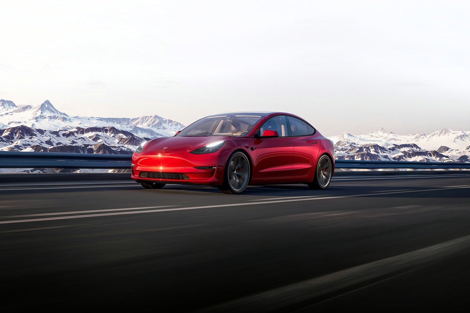 A red Tesla sedan with a mountain landscape in the background.