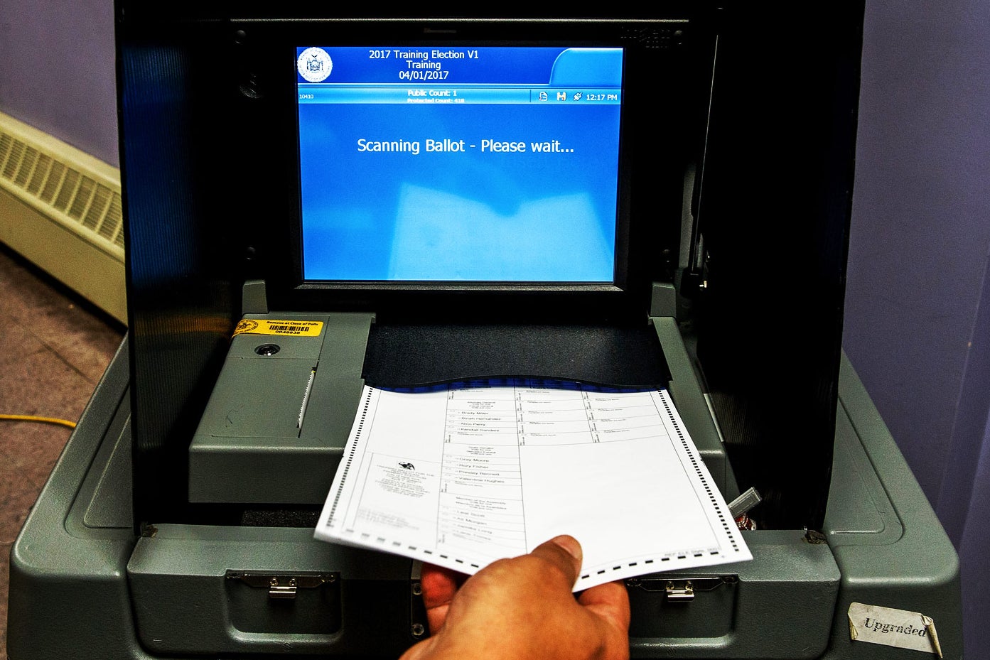 A Board of Elections employee demonstrates the use of a ballot scanner in 2016 in New York City.