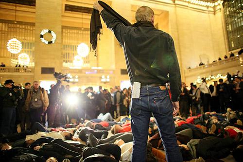 A man symbolically chokes himself with a scarf during a protest in Grand Central Terminal December 3, 2014 in New York. 