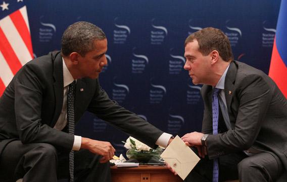 US President Barack Obama, left, speaks with Russian President Dmitry Medvedev, right.