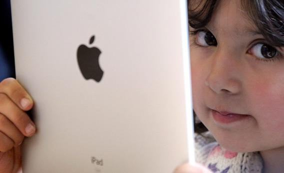 A young girl playing with an iPad.