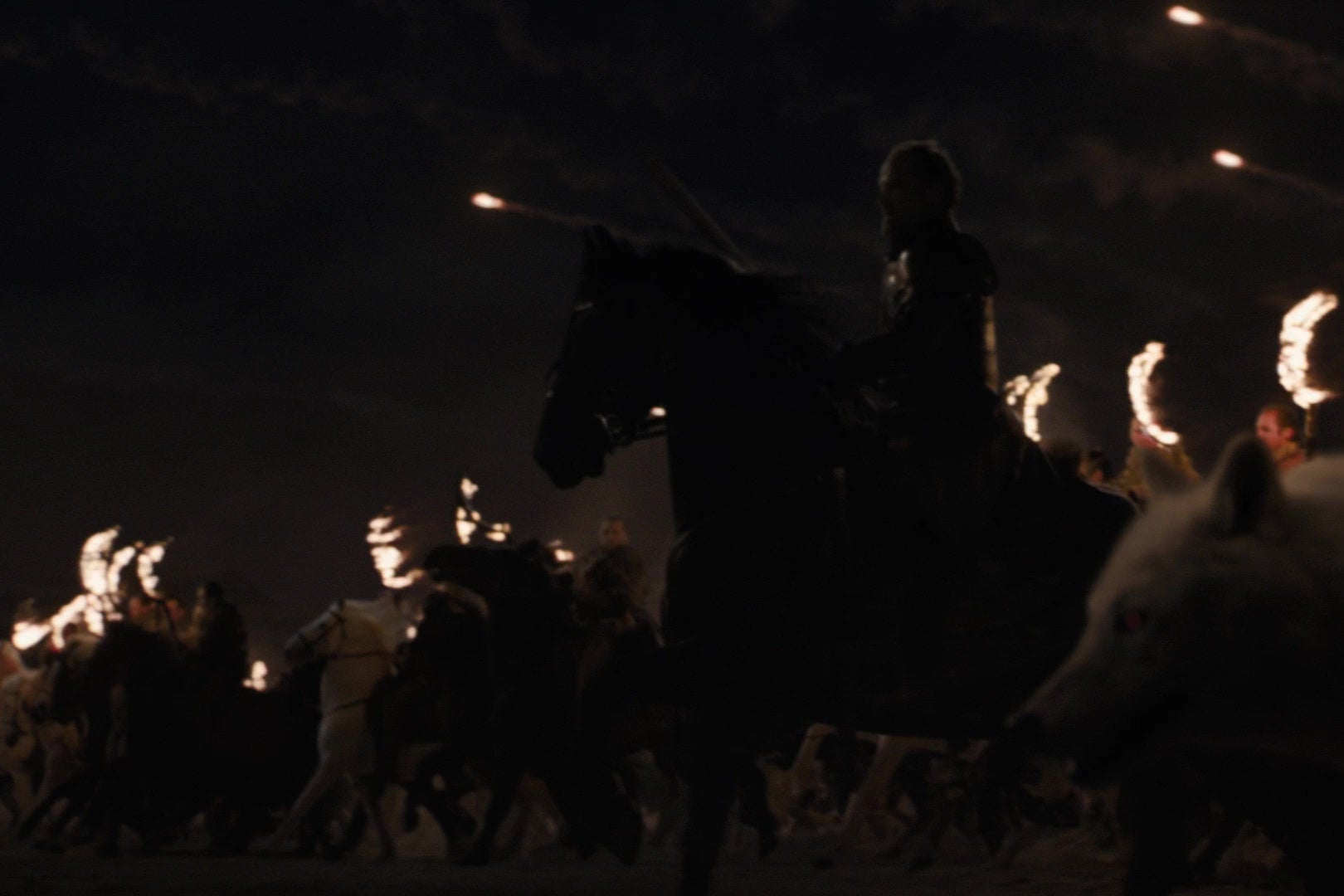 Jorah Mormont on horseback, flanked by a direwolf and rows of mounted Dothraki, charging into battle.