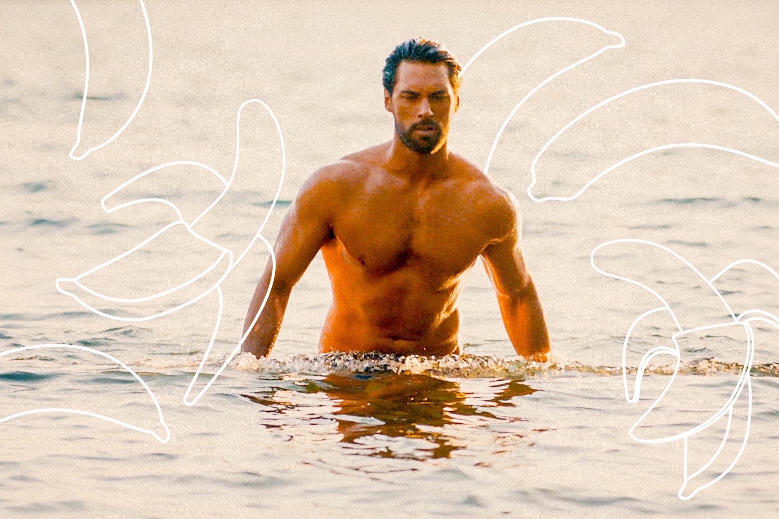 An extremely buff man rises out of the water. Over him are photoshopped a bunch of bananas.