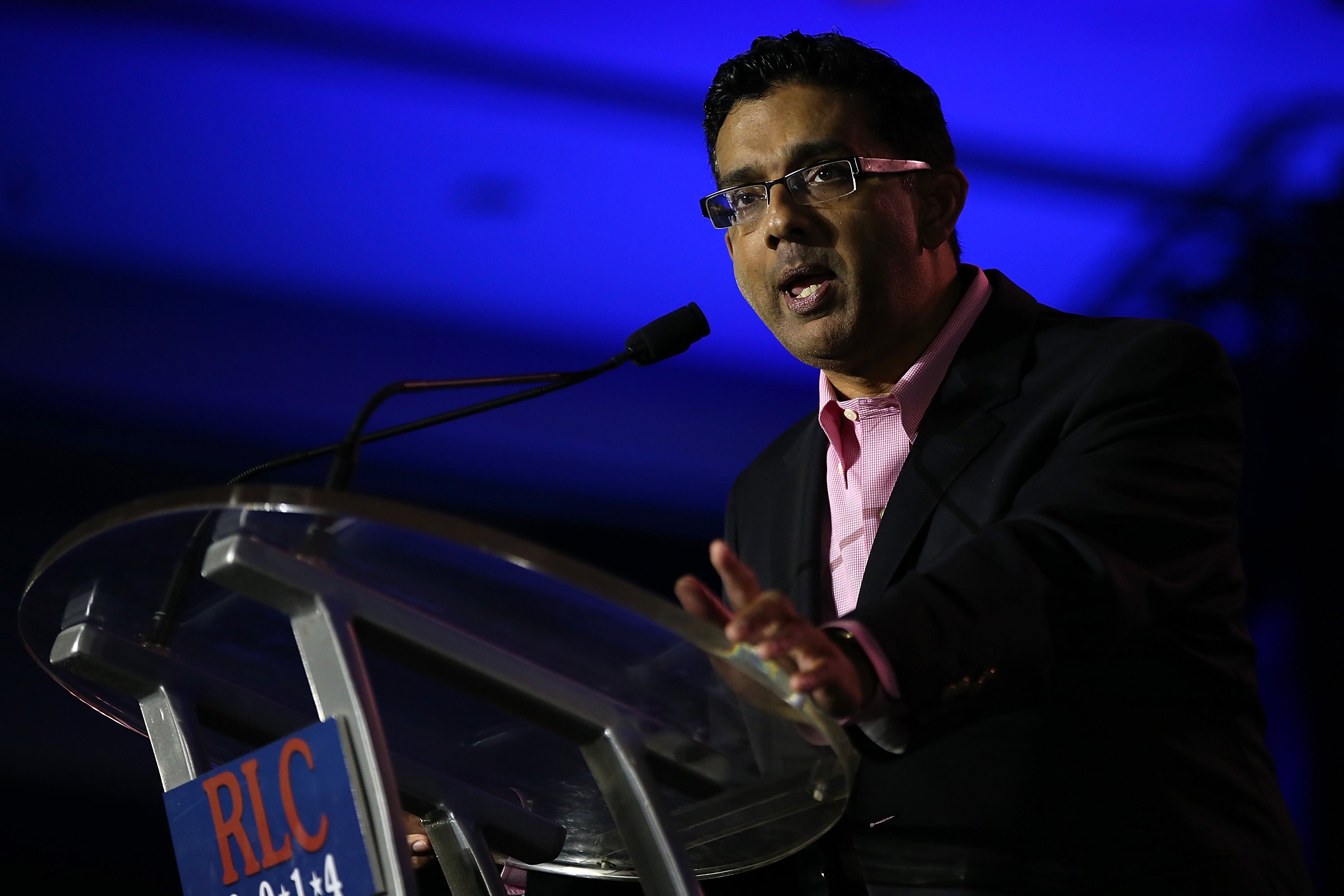 D'Souza speaks into a microphone.