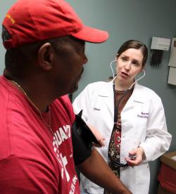 A nurse practitioner, checks a patient'x blood pressure in Lodi, Ohio July 9, 2012. 