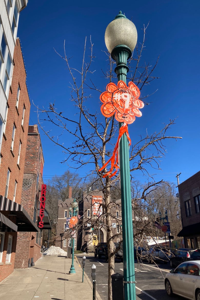A floor lamp with an orange decoration saying #9.