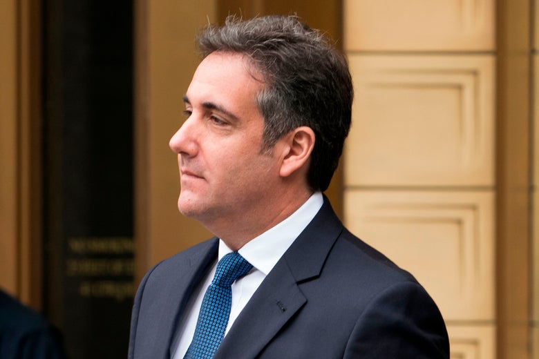Cohen walks out of a courthouse with an inscrutable expression on his face.