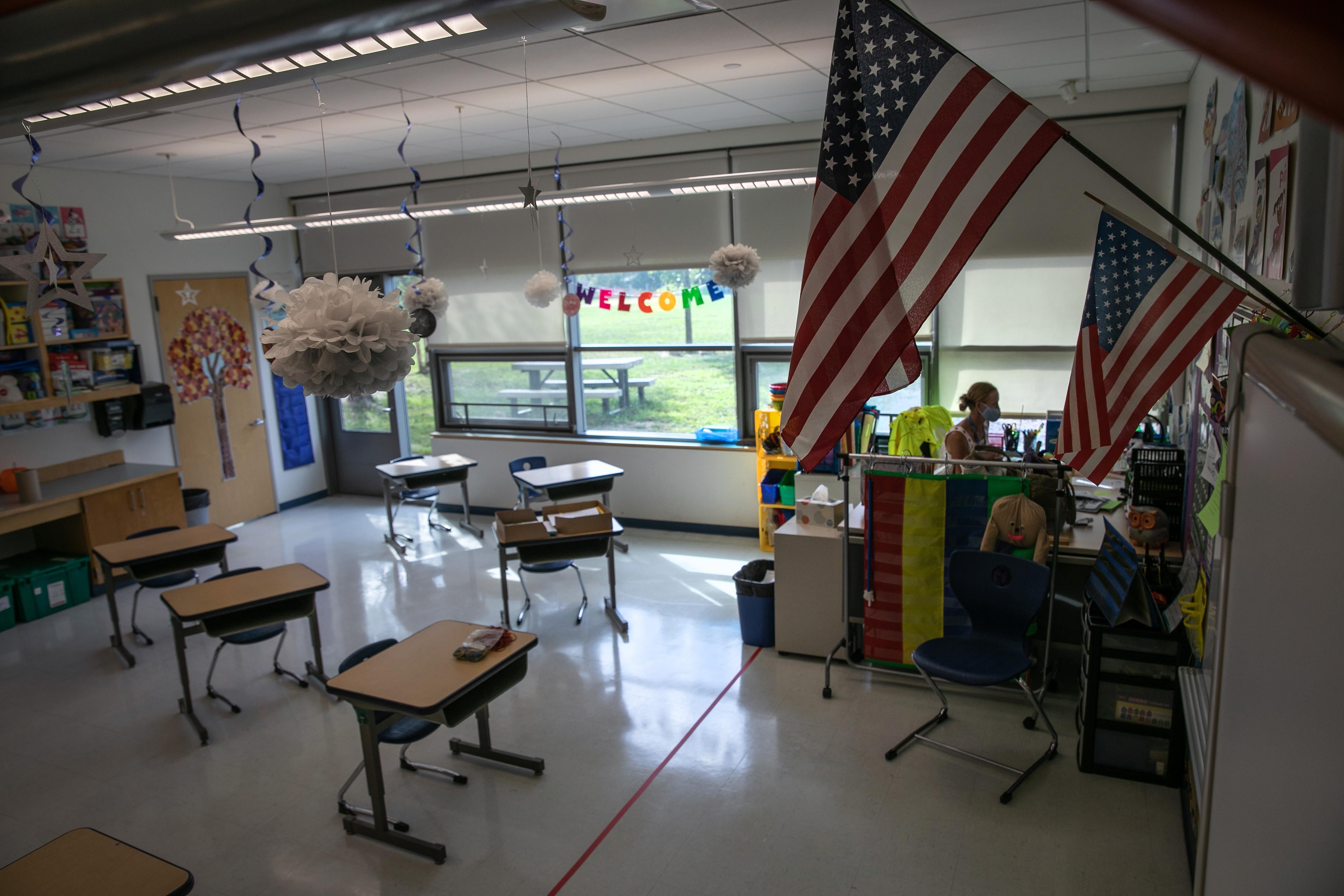 U.S. flags wave over a classroom with empty desks.