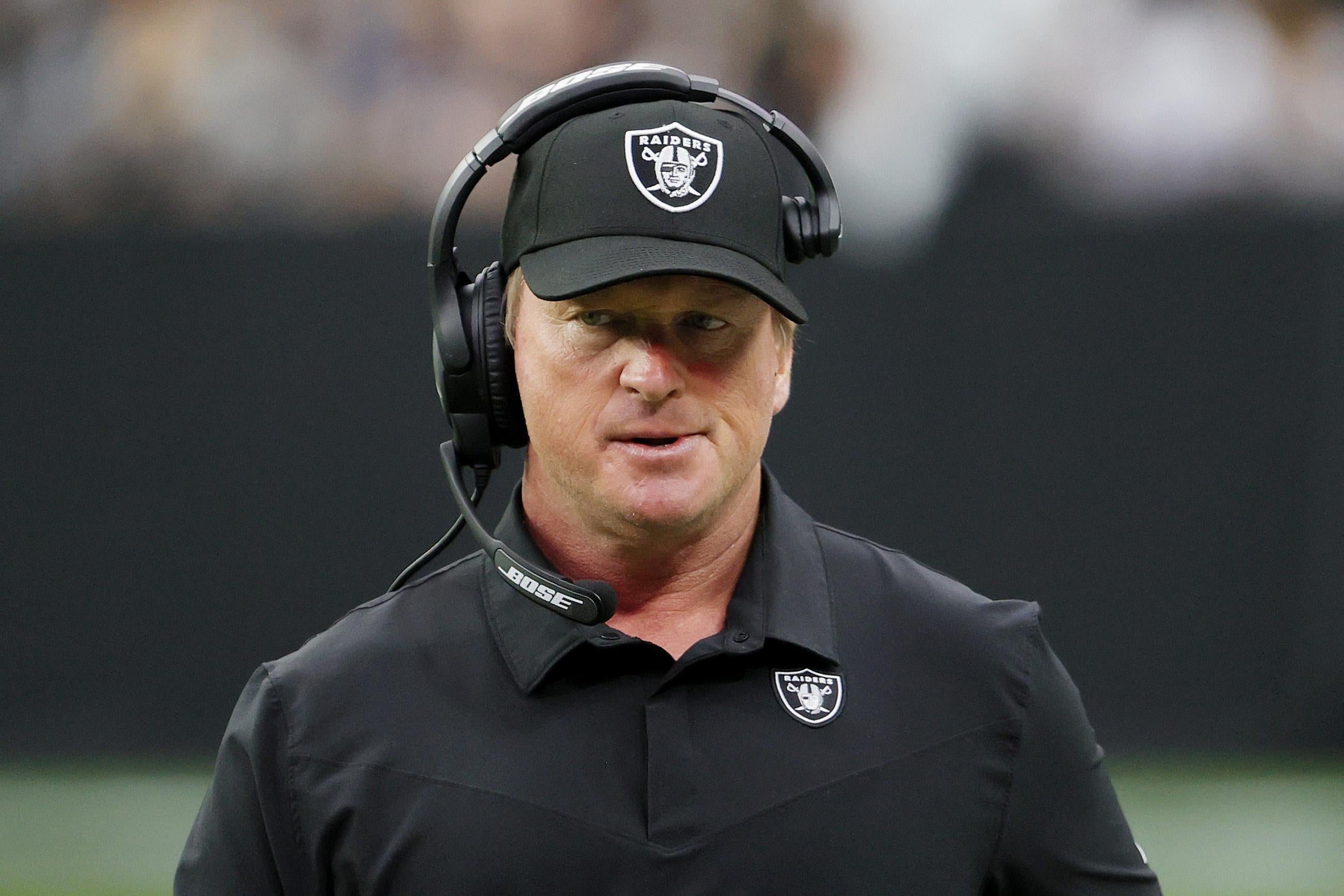 Gruden looking askance in his Raiders hat and polo and headset