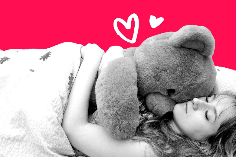 A woman lying in bed, eyes closed, hugging a giant teddy bear.