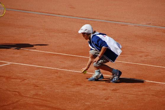A ball girl tries her best at the tennis competition. 