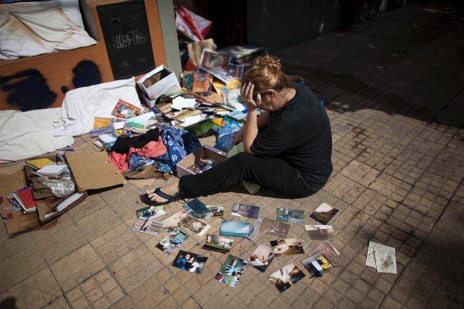Vilma Gorostiaga cries outside her home as she dries her family pictures on the ground in La Plata, in Argentina's Buenos Aires province on April 4, 2013.