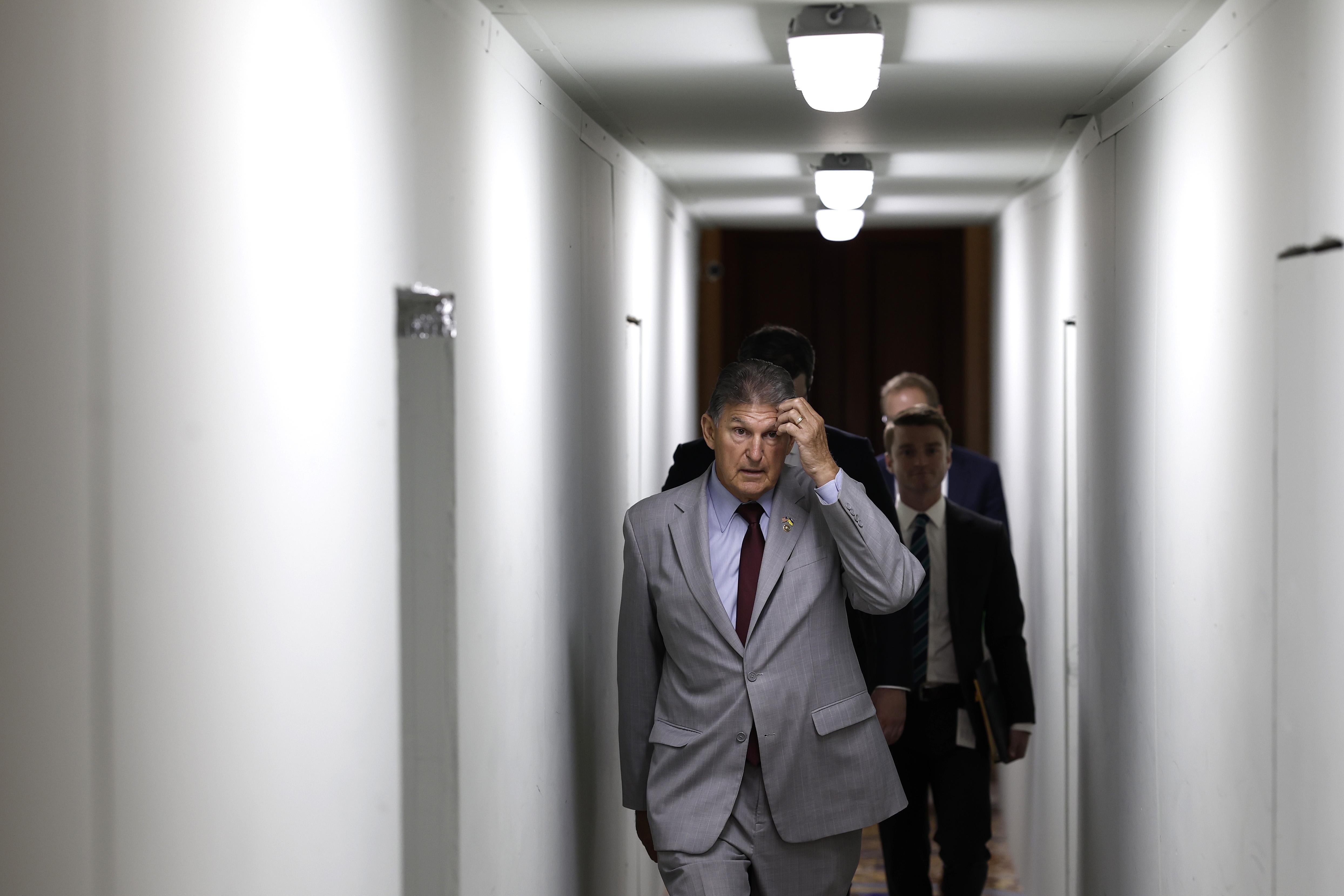 Joe Manchin walks down a hallway in the Capitol.