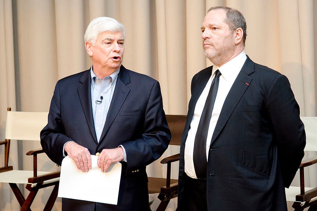 Dodd and Weinstein, wearing suits, stand in front of a row of folding canvas chairs.