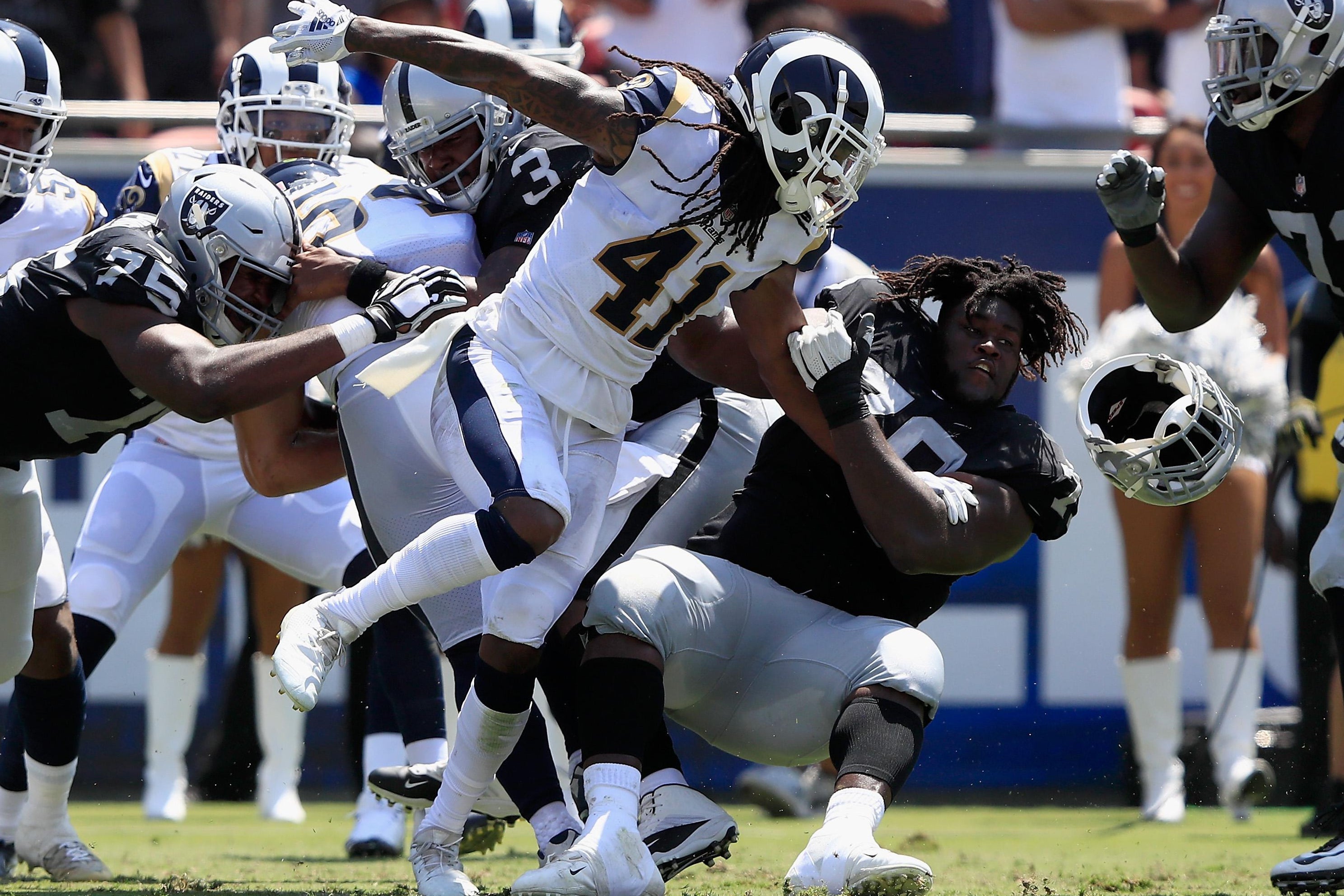LOS ANGELES, CA - AUGUST 18:  Denver Kirkland #79 of the Oakland Raiders has his helmet knocked offsides by Marqui Christian #41 of the Los Angeles Rams during the first half of a preseason game at Los Angeles Memorial Coliseum on August 18, 2018 in Los Angeles, California.  (Photo by Sean M. Haffey/Getty Images)