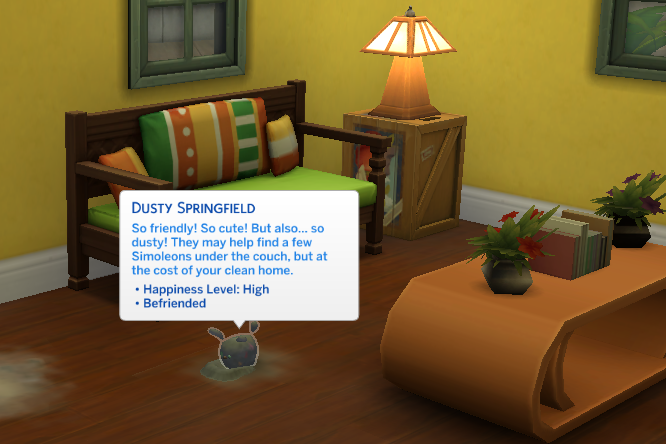 In a virtual living room, a small, blue-eyed creature sits near a pile of gray dust. A text box above reads: "Dusty Springfield. So friendly! So cute! But also ... so dusty! They may help find a few Simoleons under the couch, but at the cost of your clean home."