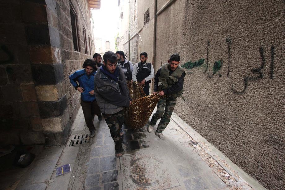 Free Syrian Army fighters carry Joseph, a 19-year-old fighter of the Aoun-bi-allah Brigade which operates under the Free Syrian Army, in a blanket after a sniper shot him in his abdomen in Aleppo on March 16, 2013.