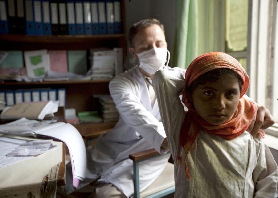 A doctor examines a young patient at a health center, in Jalalab
