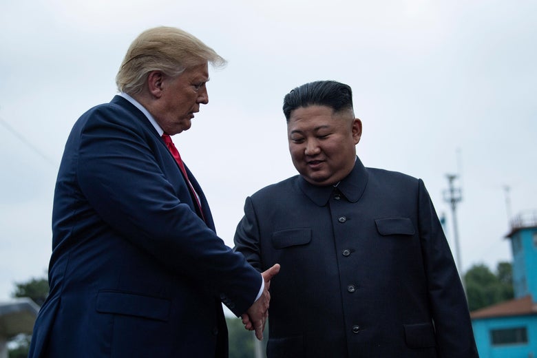 Presiden Donald Trump dan pemimpin Korea Utara Kim Jong-un berjabat tangan sebelum pertemuan di Zona Demiliterisasi (DMZ) pada 30 Juni 2019. 