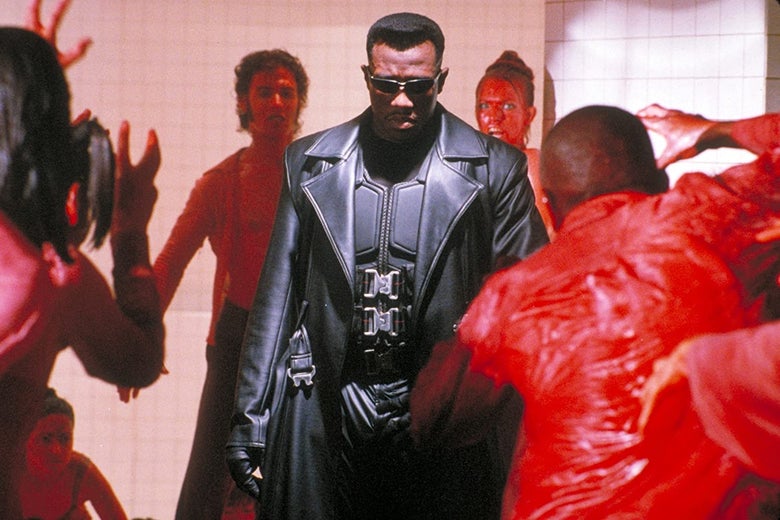 Wesley Snipes dans un trench-coat en cuir noir est entouré de personnages vêtus de rouge.