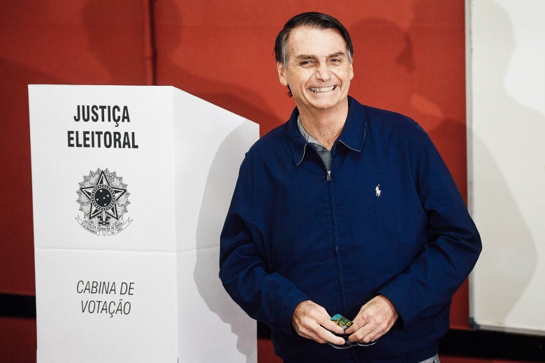 Bolsonaro standing next to a podium, grinning after casting his vote in the general election on Oct. 7.