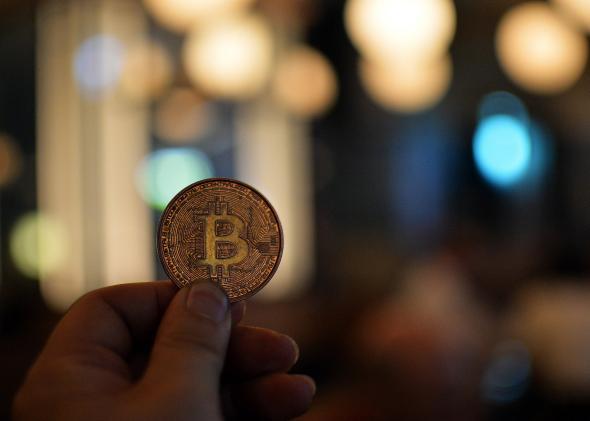 A person holds a bitcoin.
