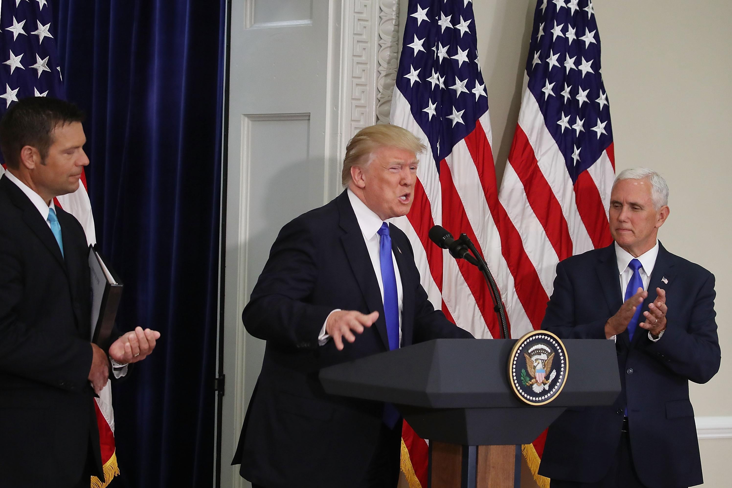 President Donald Trump speaks alongside Kansas Secretary of State, Kris Kobach (L) and Vice President Mike Pence during the first meeting of the voter fraud commission on July 19, 2017 in Washington, DC.