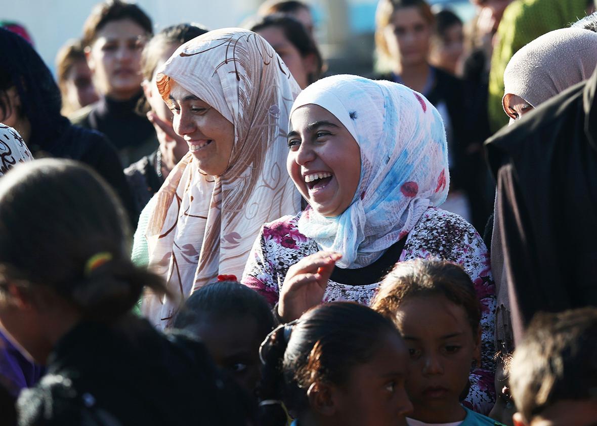 Yazidi refugees celebrate news of the liberation of their homeland of Sinjar from ISIL, while at a refugee camp on November 13, 2015 in Derek, Syria.  