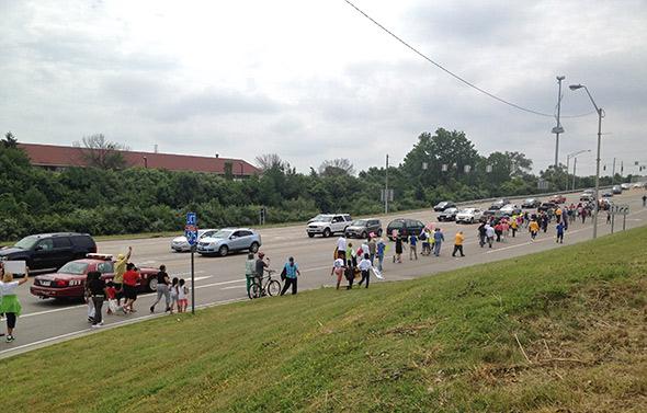 Dayton residents march along a highway to protest the lack of bus service to area malls in June 2013.