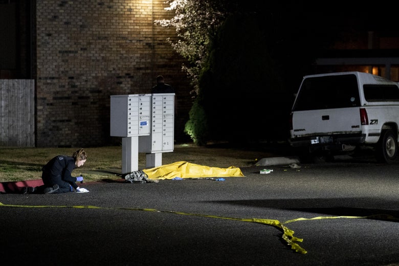 Investigators work near a tarpaulin covering the body of a man who is reportedly Michael Forest Reinoehl after he was shot and killed by law enforcement on September 3, 2020 in Lacey, Washington.