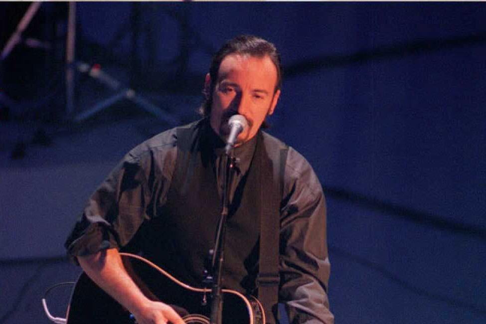 Bruce Springsteen plays guitar and sings onstage.