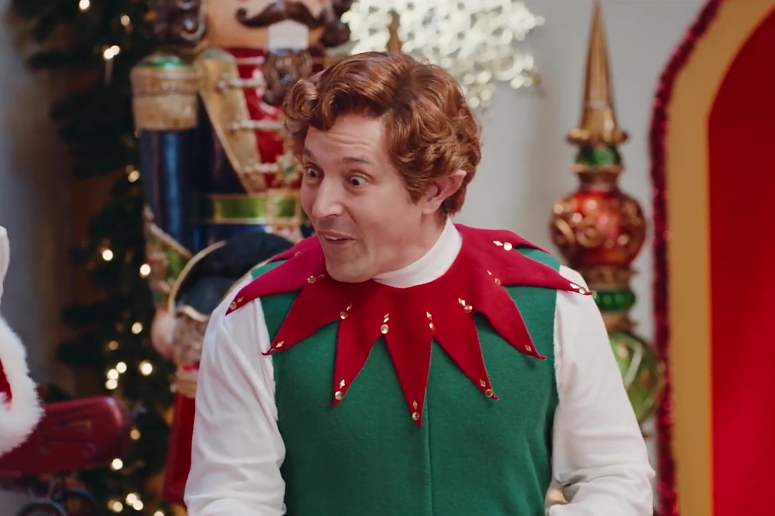 Beck Bennett dressed as one of Santa's Elves, making an extremely silly face.