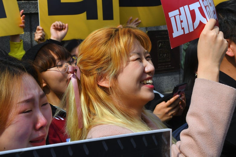 South Korean women hold up banners to protest anti-abortion legislation.