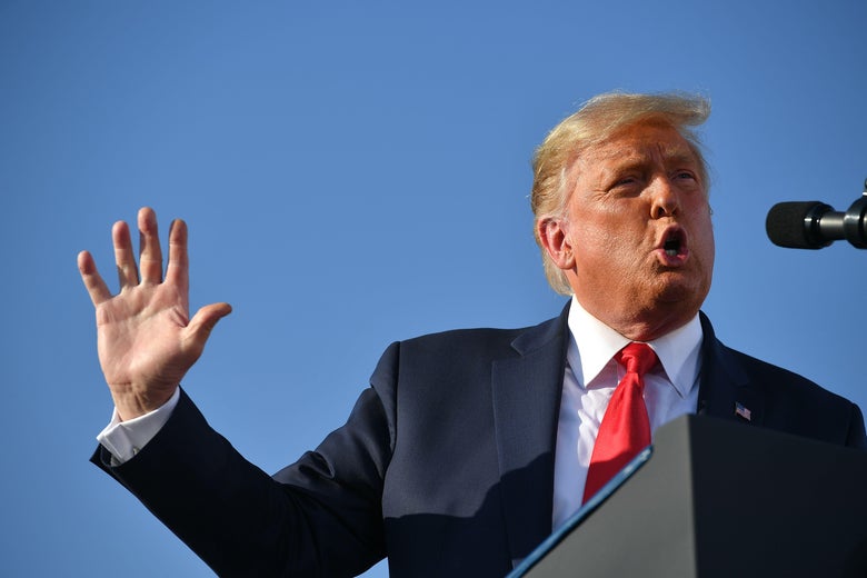 Trump speaking into a mic and waving his arm