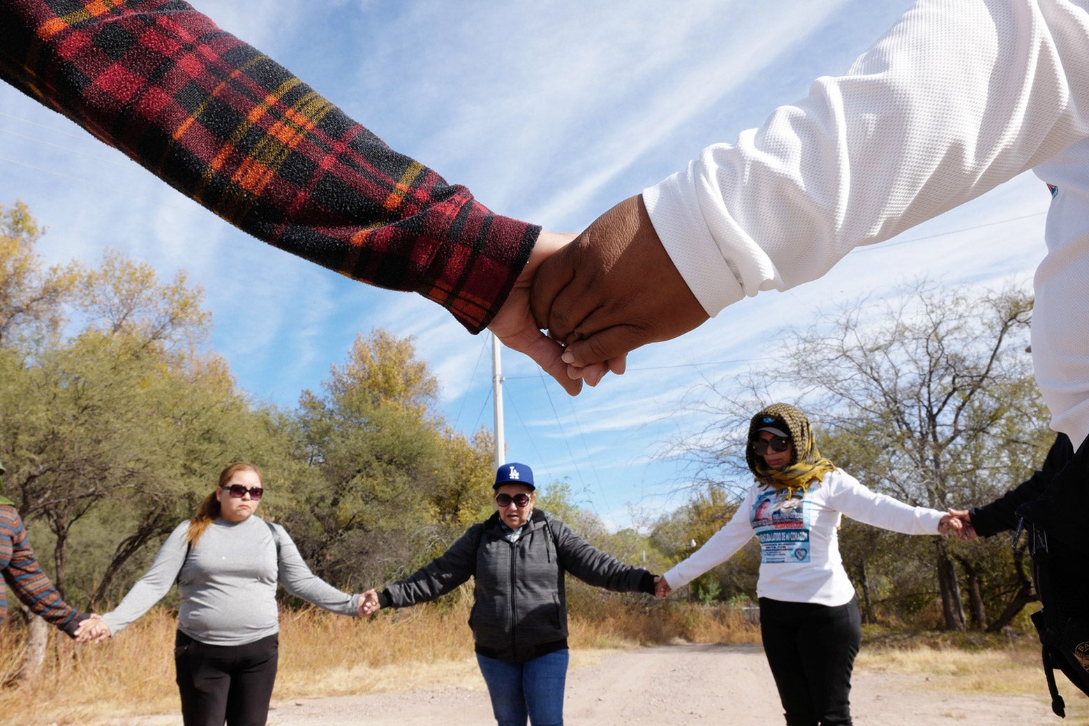 Cecilia leads women holding hands in a circle in a prayer before a search for remains of the disappeared in northern Sonora, Mexico in November 2022. 