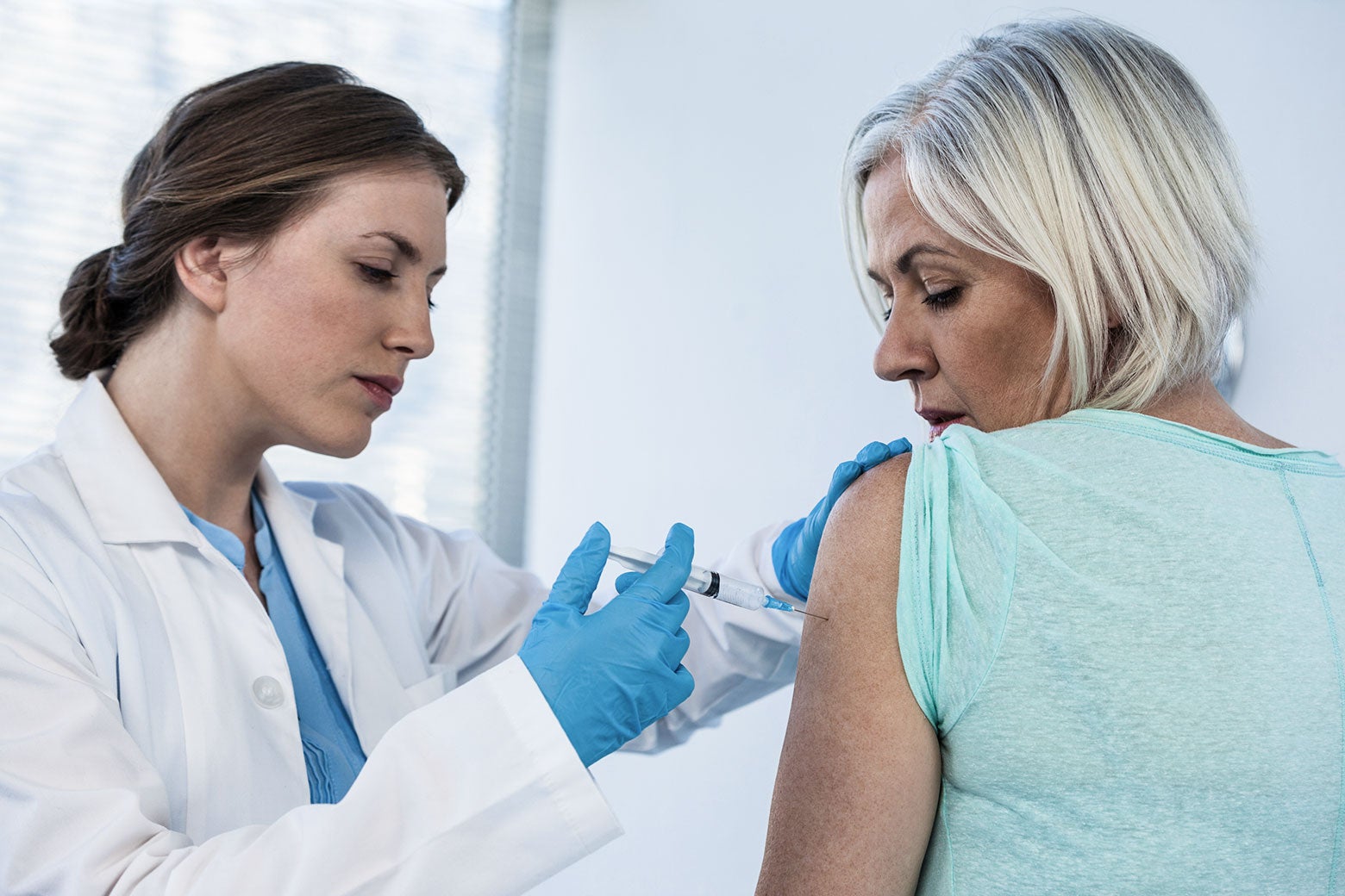 A woman getting a shot from a doctor.