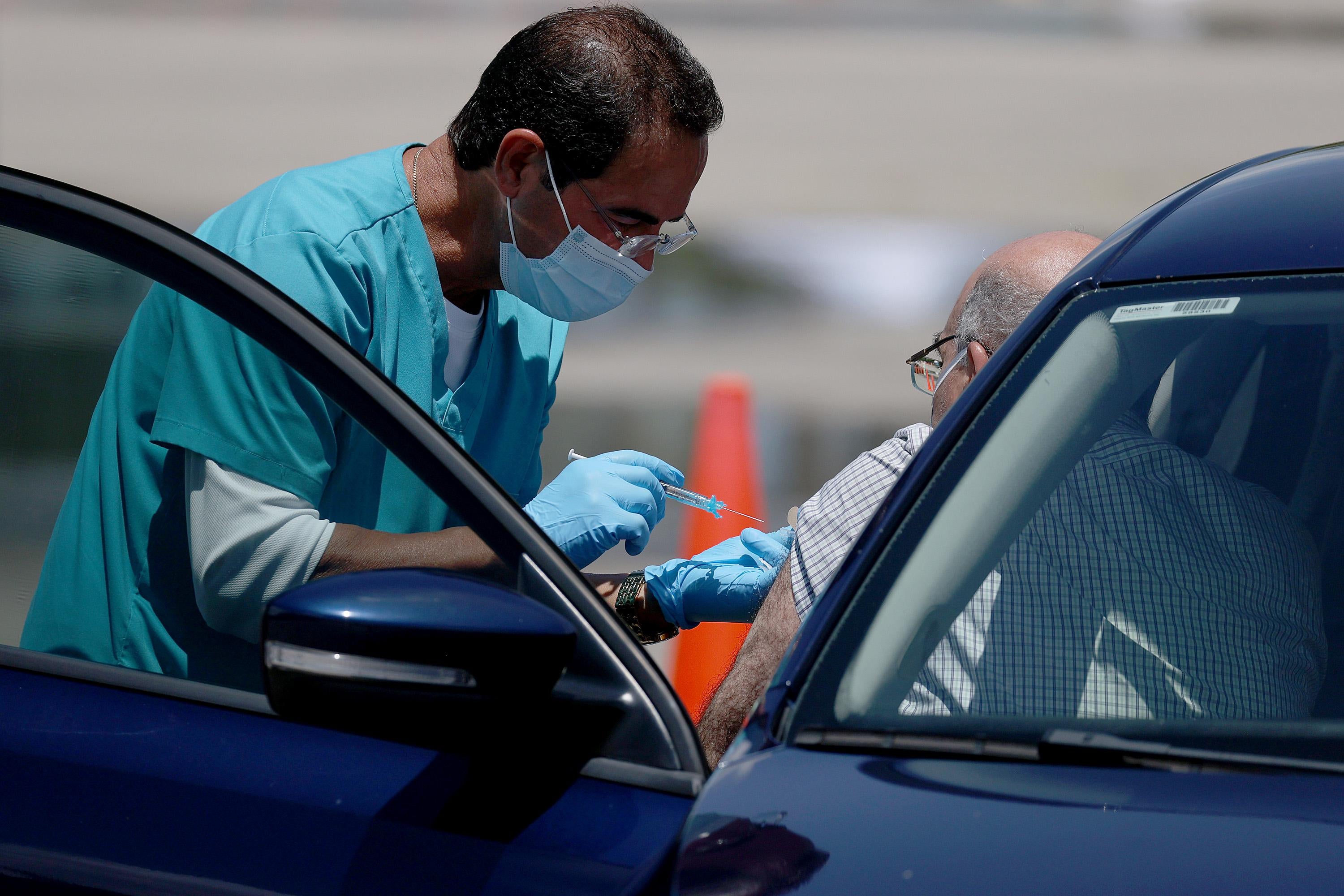 A healthcare worker at a drive-thru site setup by Miami-Dade and Nomi Health in Tropical Park prepares to administer a COVID-19 vaccine on July 26, 2021 in Miami, Florida. 