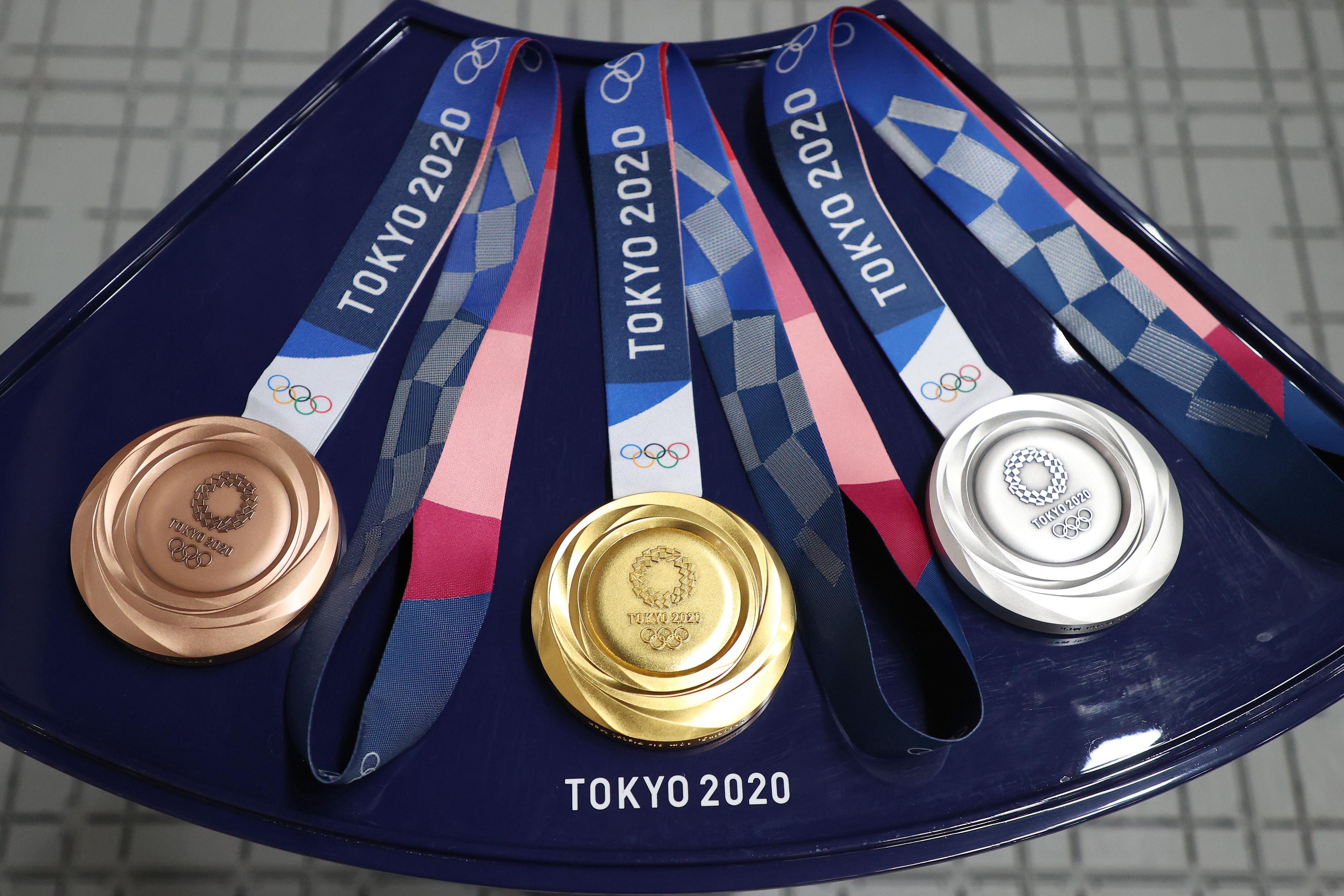 L-R: a bronze, gold, and silver medal from the Tokyo Olympics sitting on a platter.
