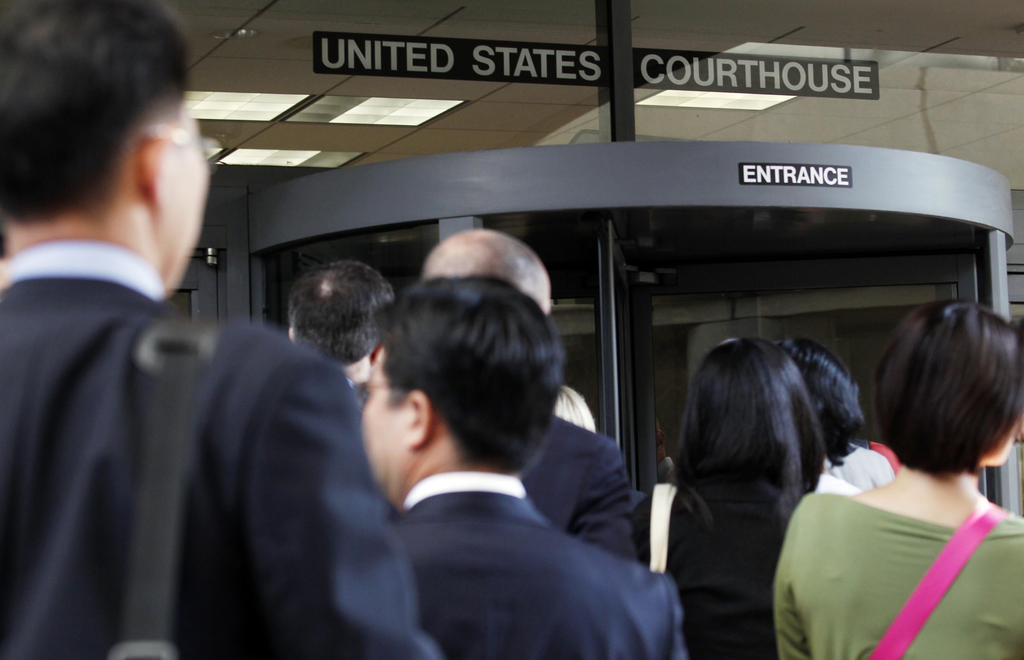 Individuals line up to enter the Robert F. Peckham United States Courthouse Building to watch Apple and Samsung face each other in federal district court for a patent infringement case on July 30, 2012 in San Jose, California.