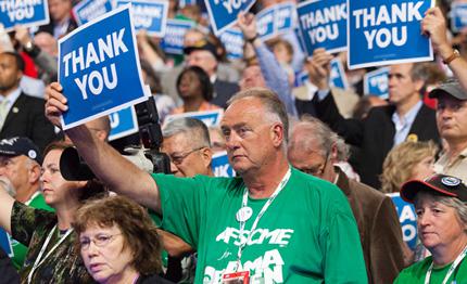 A delegate holds a thank you sign on the final day of the Democratic National Convention. 