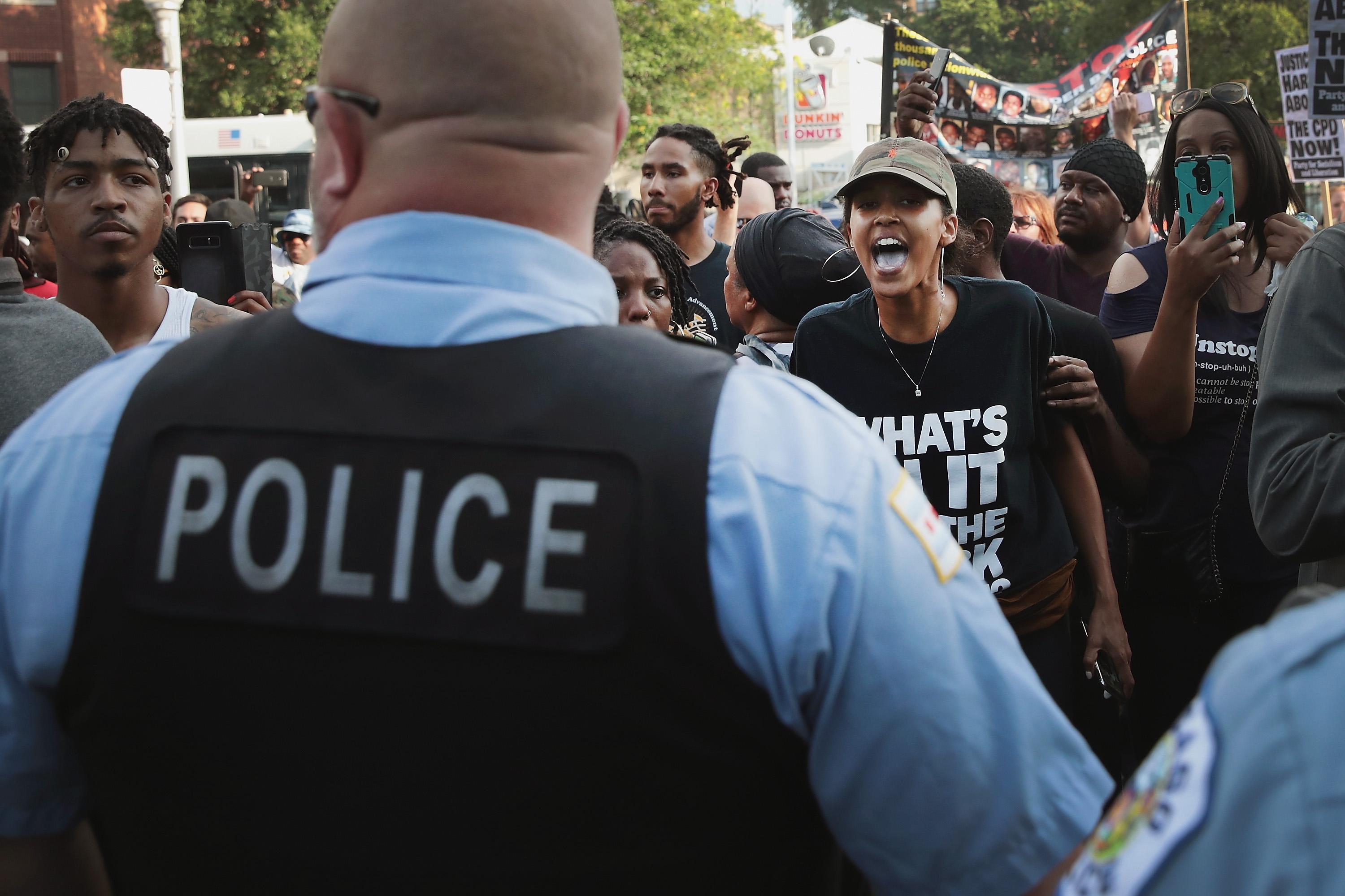 Protestors yelling at Chicago police officers.