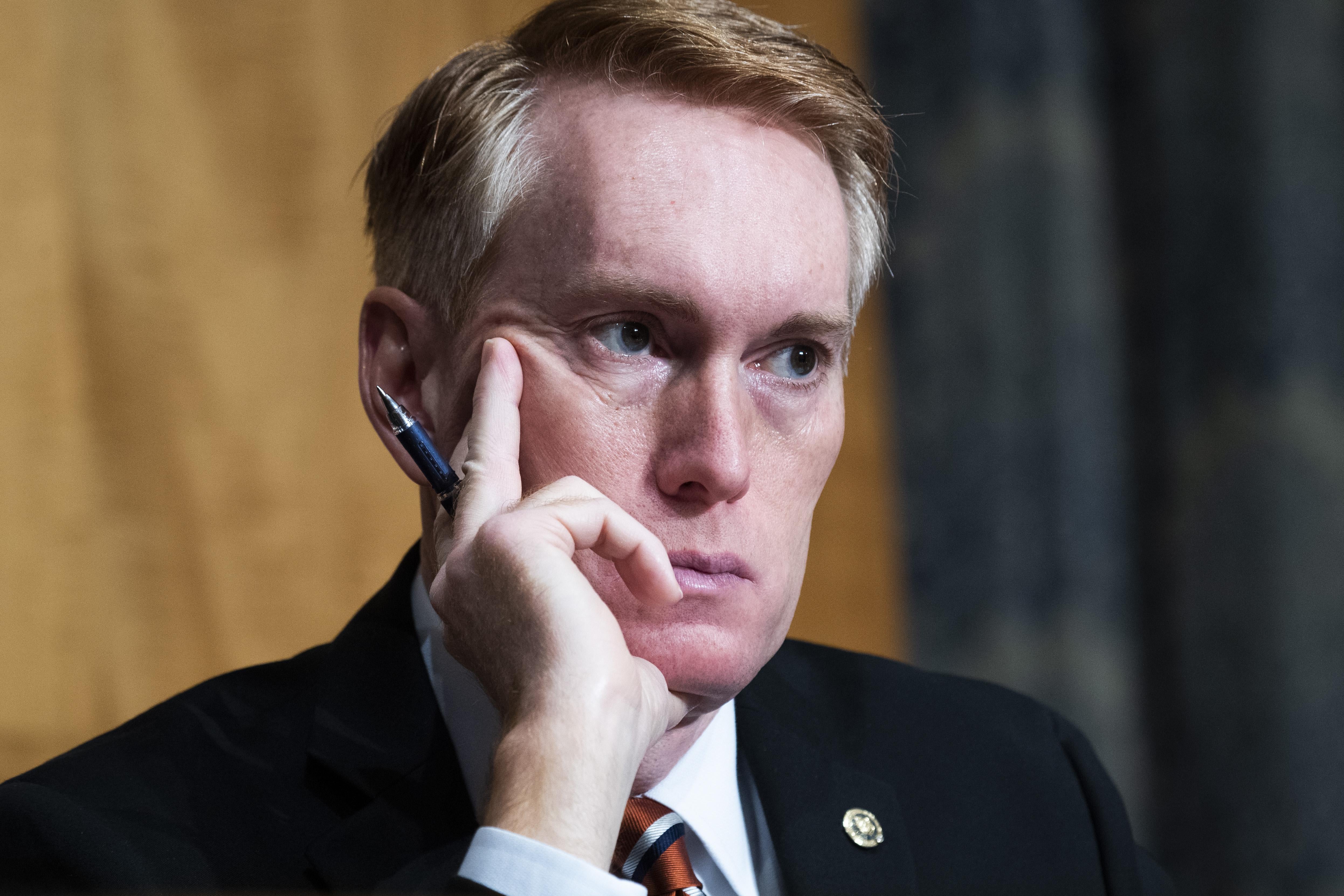 Republican Sen. James Lankford of Oklahoma sits with his hand, holding a pen, on his cheek. 