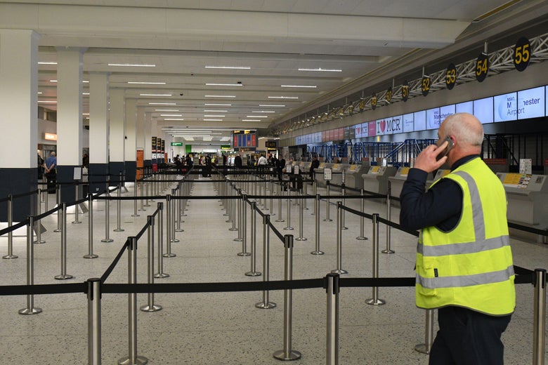 A man in a high-visibility vest looks at an empty terminal.