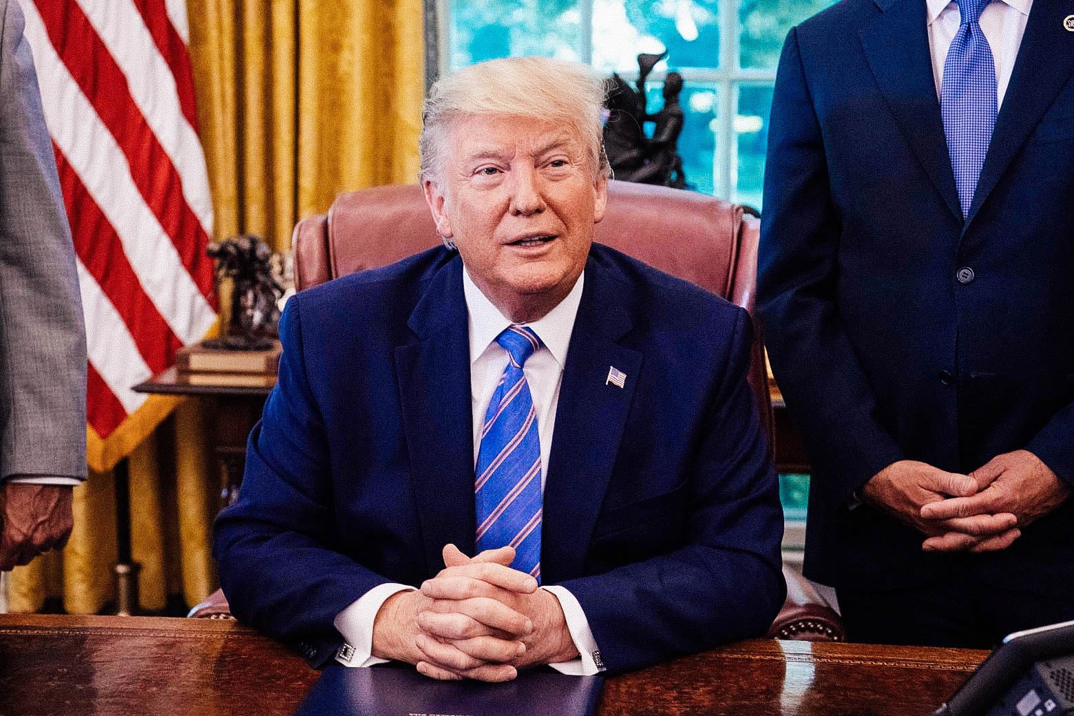 Donald Trump sits at his desk in the Oval Office.