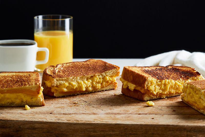 Cheesy breakfast sandwiches with orange juice.